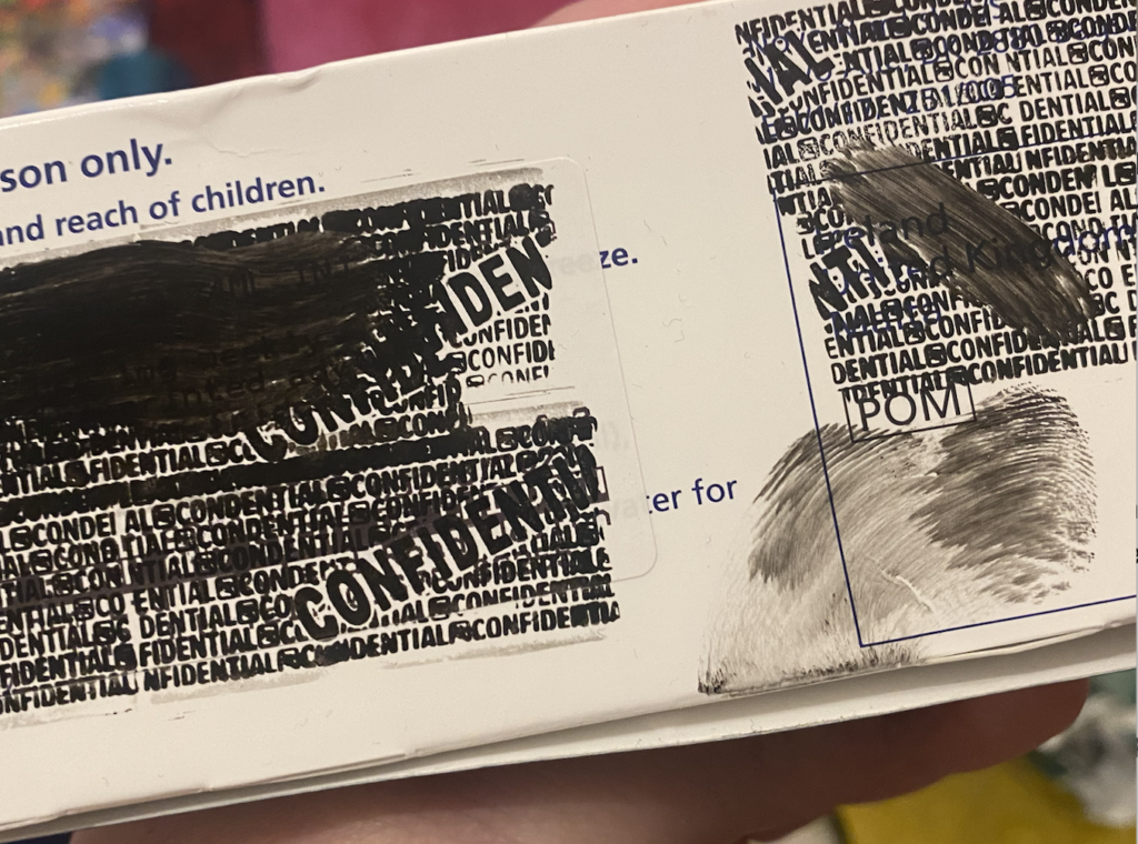 Redaction on a shiny cardboard showing smudges.